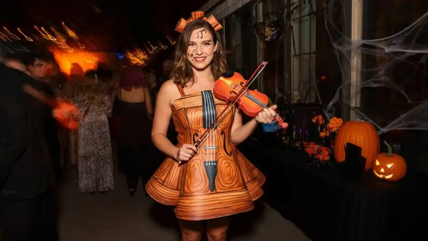At a lively Halloween party, Violin Vickie steals the spotlight with her enchanting costume.